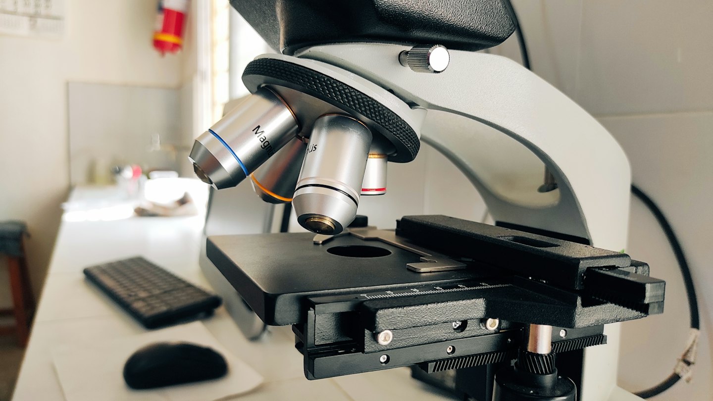 Un microscopio de laboratorio moderno con lentes objetivos detallados.